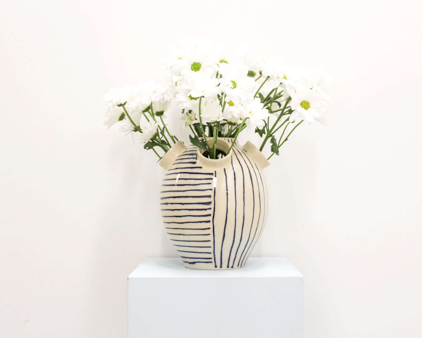 Handmade Striped ceramic vase with flowers on a white background from Mima Ceramics by Michelle Organ. 