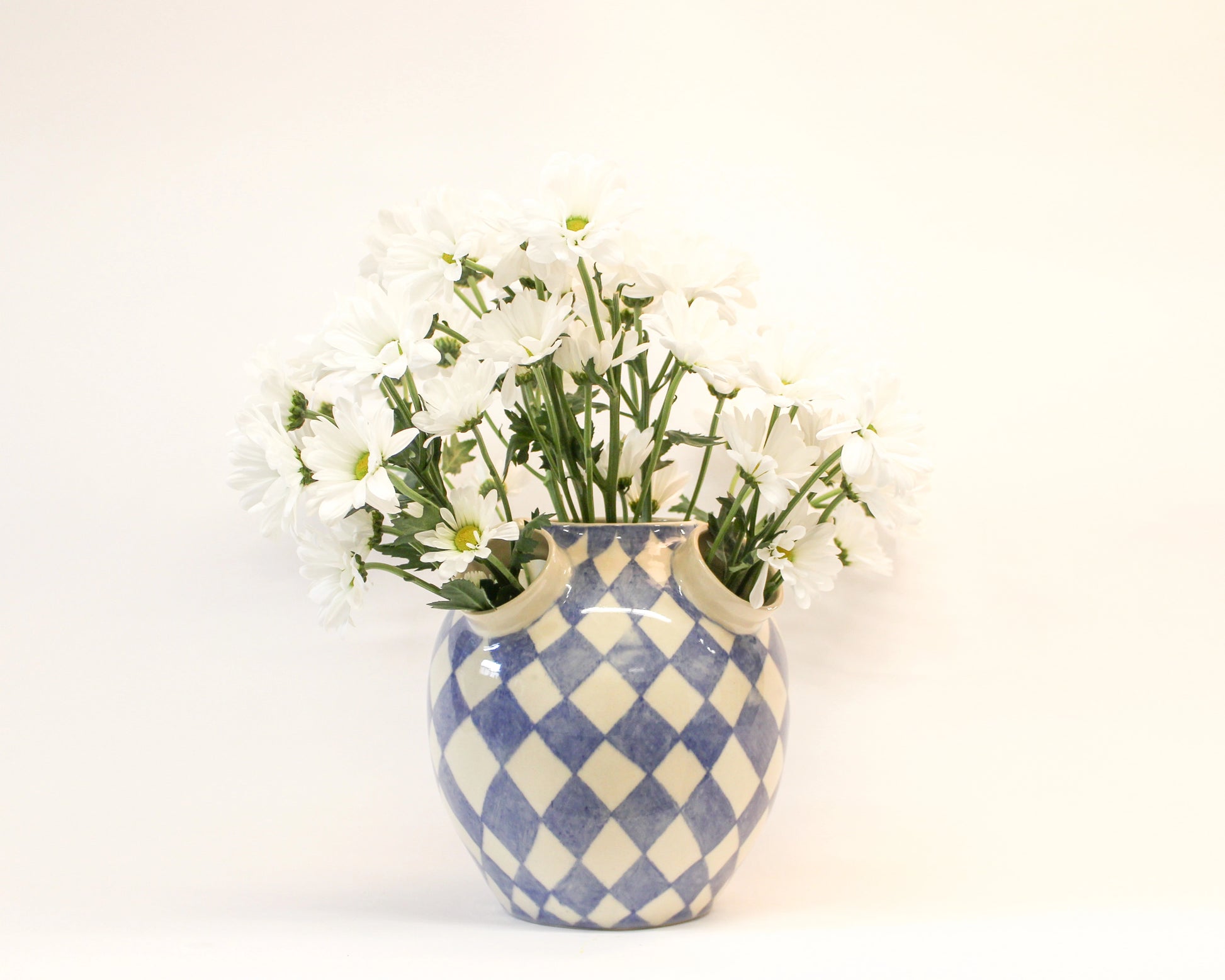 Handmade Blue and white checkered vase with white flowers on a light background from Mima Ceramics by Michelle Organ. 