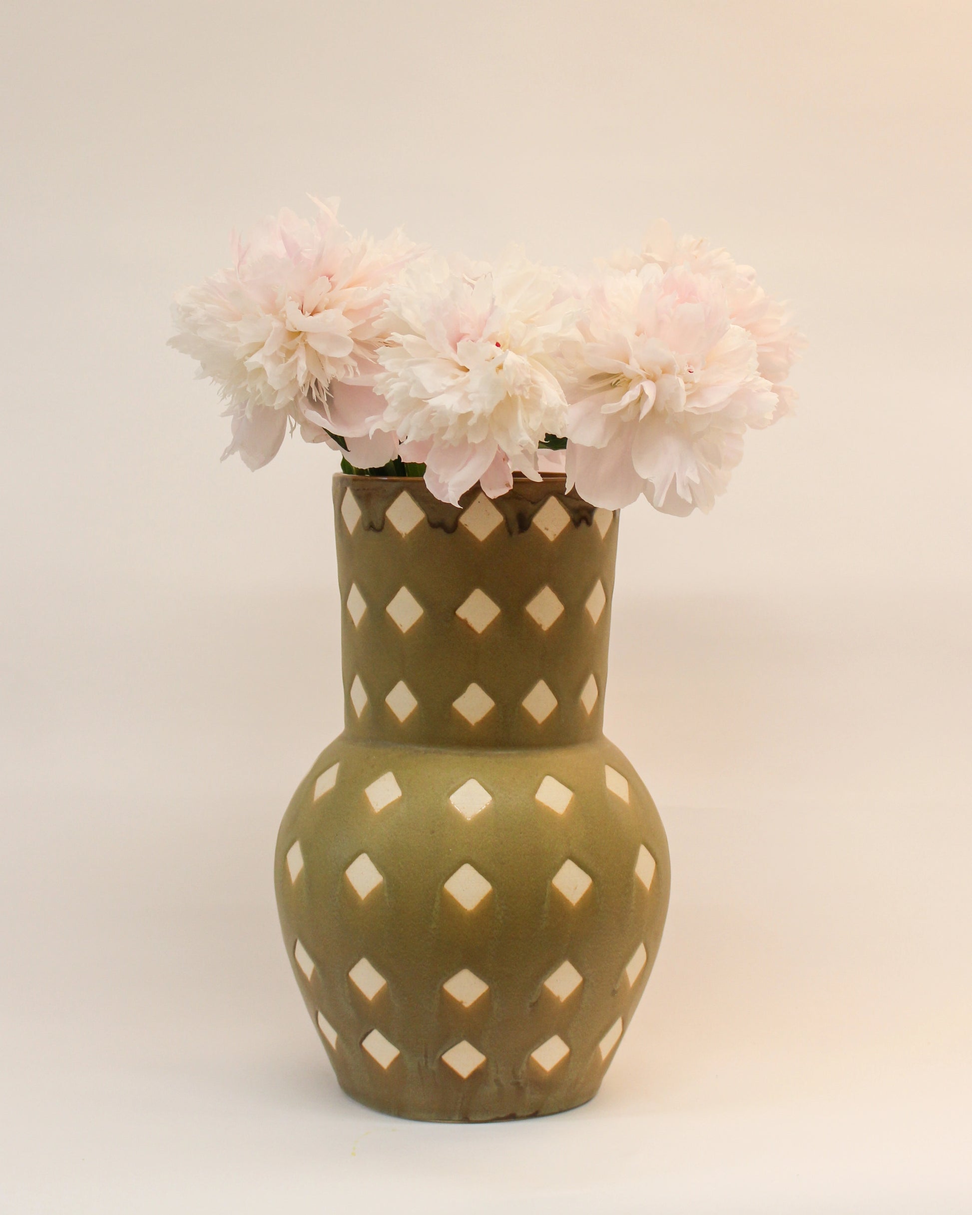 Decorative Handmade Olive Green Ceramic Vase with a diamond print pattern filled with light pink flowers from Mima Ceramics by Michelle Organ. 