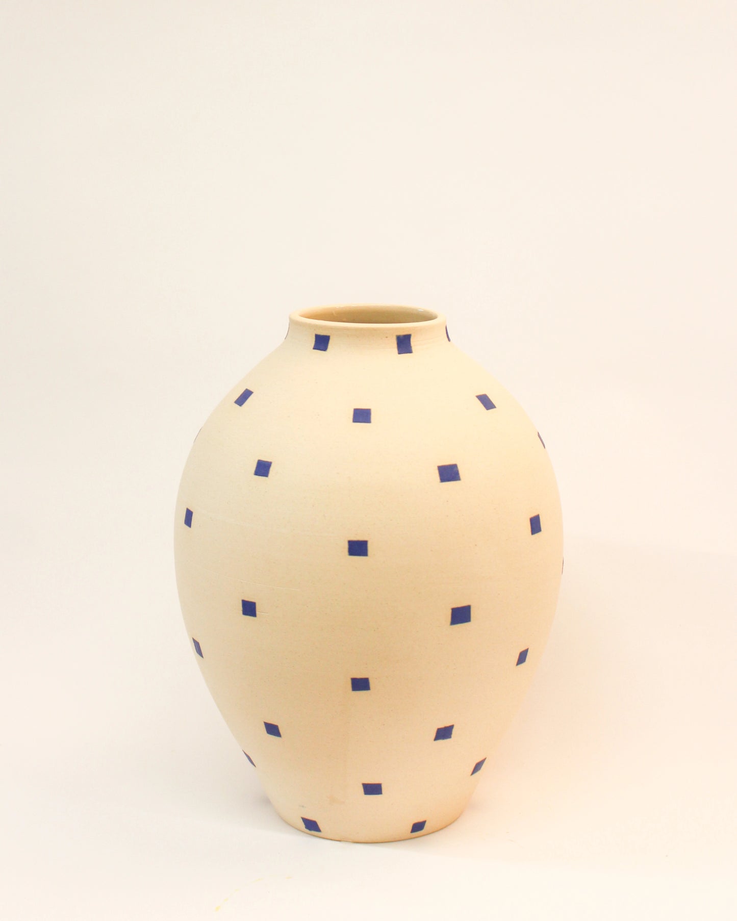 Handmade Round Cream-colored vase with blue polka dots on a light beige background from Mima Ceramics by Michelle Organ.